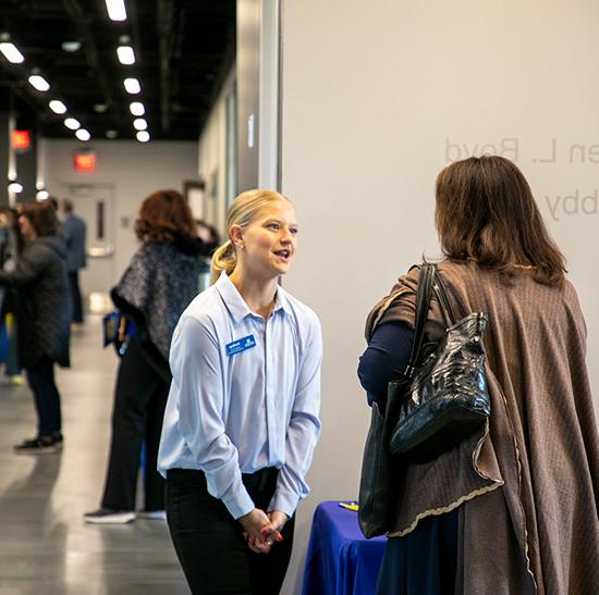 Admissions officer enjoying a chat with a visitor to the university